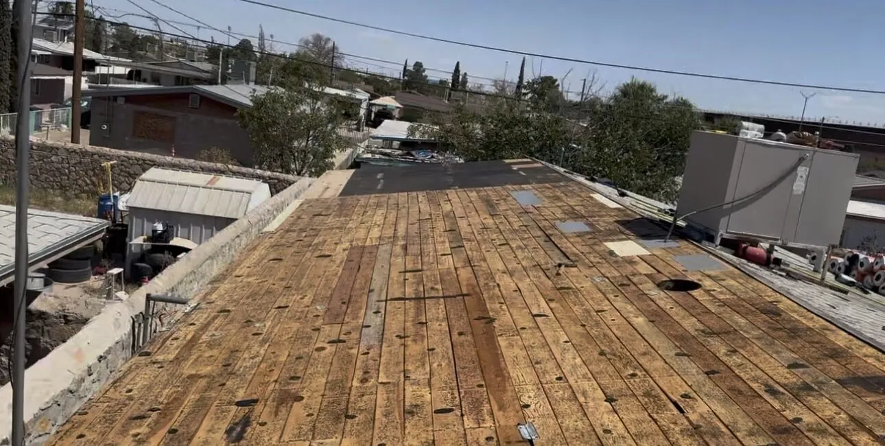 Shingles removed down to the bare wood deck, with the bad boards marked for replacement