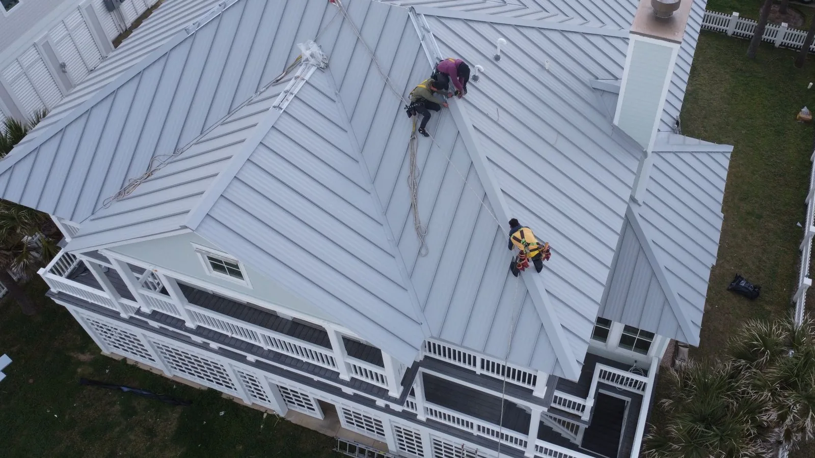 Crew tied off on a standing seam roof