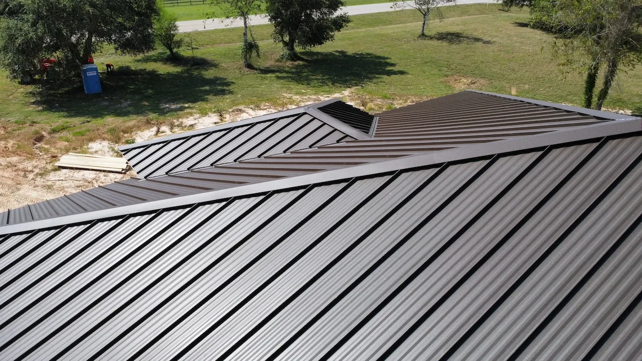 Standing seam metal roof panels meeting at a ridge, project photo