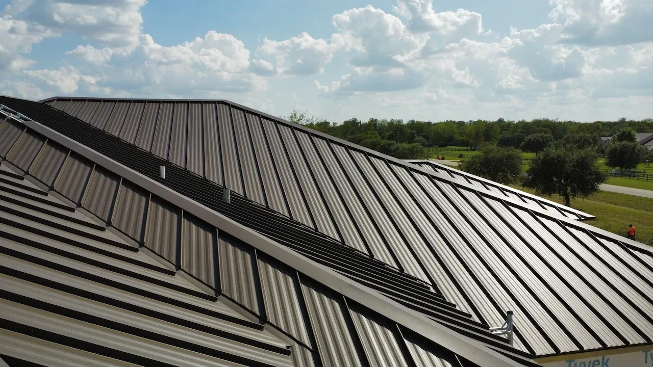 Dark standing seam metal roof under a cloudy sky
